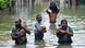 People in waist high water hold their belongings in plastic bags in Wellampitiya on the outskirts of Colombo, Sri Lanka People in waist high water hold their belongings in plastic bags in Wellampitiya on the outskirts of Colombo, Sri Lanka