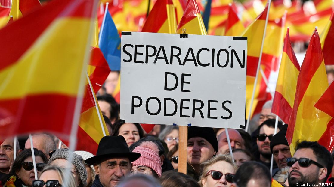 İspanya'da hükümette yolsuzluk iddialarına karşı düzenlenen bir eylem ve ellerinde bayraklarla döviz tutan protestocular