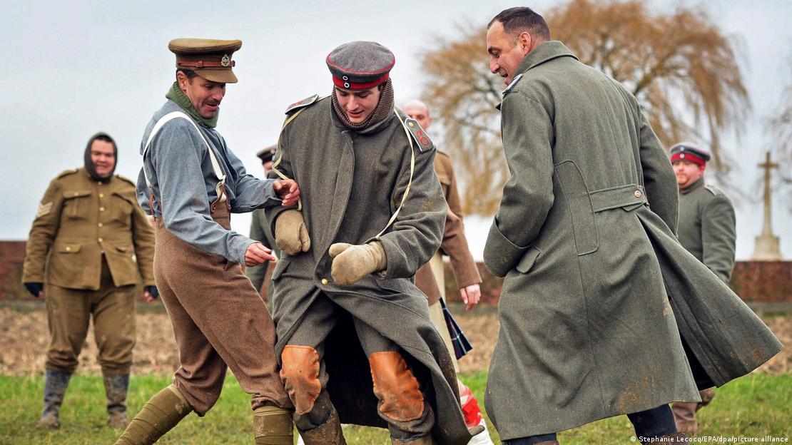 Men in historical uniforms play soccer together.