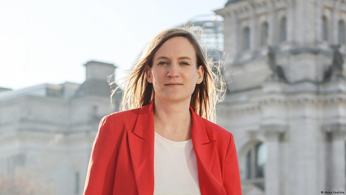 Frau mit rotem Blazer und weißem Shirt steht vor dem Reichstag: SPD-Politikerin Carmen Wegge