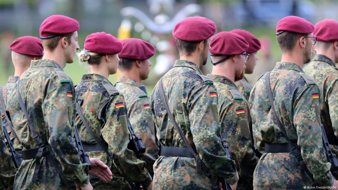 Almanya'da kısi zorunluluk içeren yeni askerlik modeli, 18 yaşına gelmiş erkeklerin yoklamaya çağrılmasını, yaşıtı genç kızların ise yokmalaya  gönüllü  katılımını öngörüyor. Buna, hem ülkedeki asker potensiyelinin ölçülmesi hem de hedeflenen asker sayısına gönüllülük yoluyla ulaşılıp ulaşılamayacağının test edilmesi olarak bakılıyor. Fotoğrafta bordo ereli bir grup asker görülüyor 