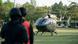 Ein thailändischer Militärhubschrauber, davor zwei Personen mit Helmen Ein thailändischer Militärhubschrauber, davor zwei Personen mit Helmen