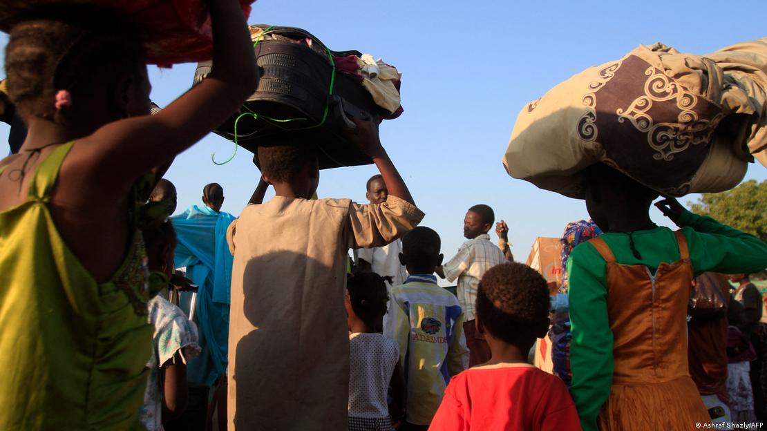 South Sudanese refugees carrying belongings as they flee fighting