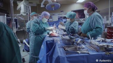 Image 12: Doctors and nurses in an operation theater working on a heart transplant 