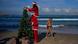 Surfistas vestidos de Papá Noel decoran un árbol de Navidad en la playa de Tel Aviv. Surfistas vestidos de Papá Noel decoran un árbol de Navidad en la playa de Tel Aviv.