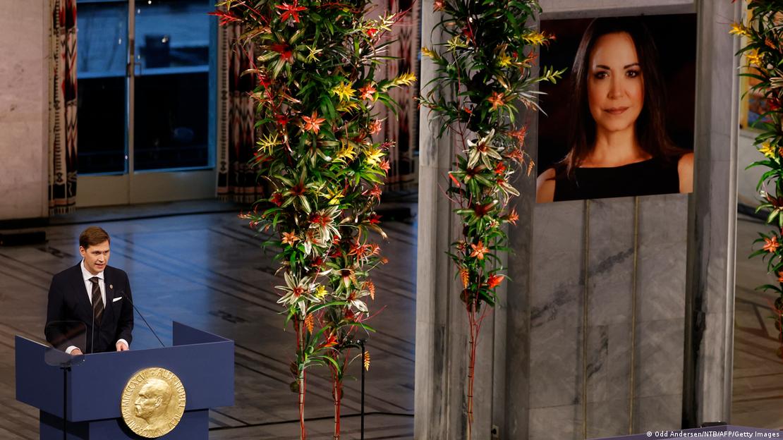 Imagen de María Corina Machado en la ceremonia de entrega de su Premio Nobel de la Paz en ausencia en Oslo. Junto a la fotografía, Jorgen Watne Frydnes, presidente del Comité del Nobel, da un discurso. Imagen de María Corina Machado en la ceremonia de entrega de su Premio Nobel de la Paz en ausencia en Oslo. Junto a la fotografía, Jorgen Watne Frydnes, presidente del Comité del Nobel, da un discurso.