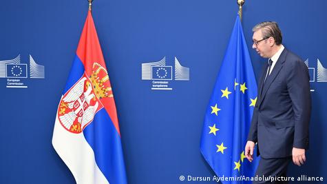 Presidenti serb Aleksandar Vuçiq, duke ecur në korridoret e Komisionit Europian në Bruksel, mes flamujve të BE-së dhe Serbisë