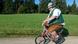 An overweight man dressed in traditional Bavarian costume rides a tiny bicycle. An overweight man dressed in traditional Bavarian costume rides a tiny bicycle.