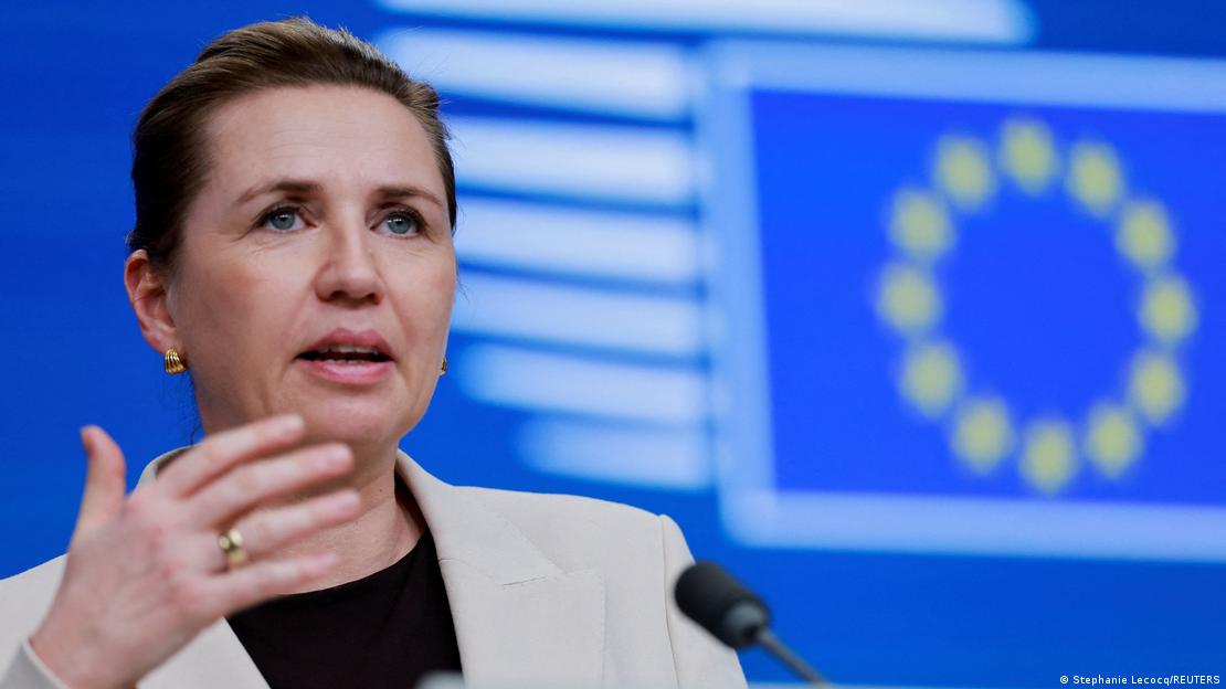 Жена со подигната рака зборува додека зад неа е лого на ЕУ - Мете Фредериксен, премиерка на Данска Жена со подигната рака зборува додека зад неа е лого на ЕУ - Мете Фредериксен, премиерка на Данска