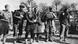 Russian forced laborers, both men and women, during World War II, seen in a black and white photo. They are standing in a field. Russian forced laborers, both men and women, during World War II, seen in a black and white photo. They are standing in a field.