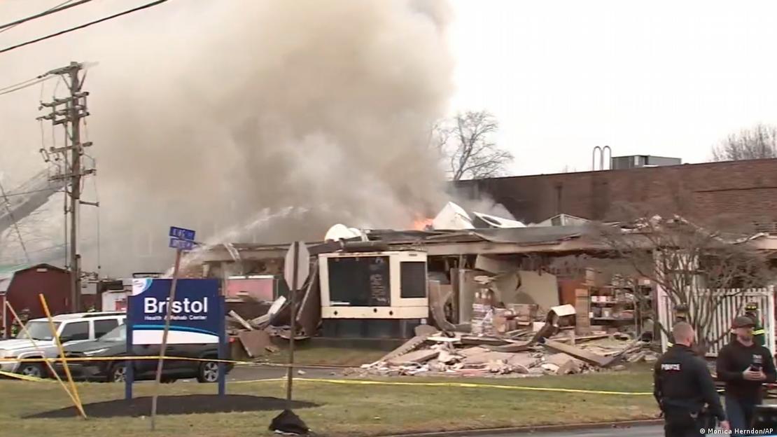 A hose sprays water at a partially collapsed building
