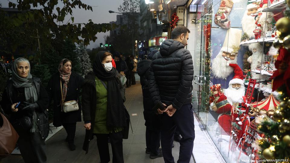 A group of people look at a shop window selling Christmas ornaments on Dec 24, 2025