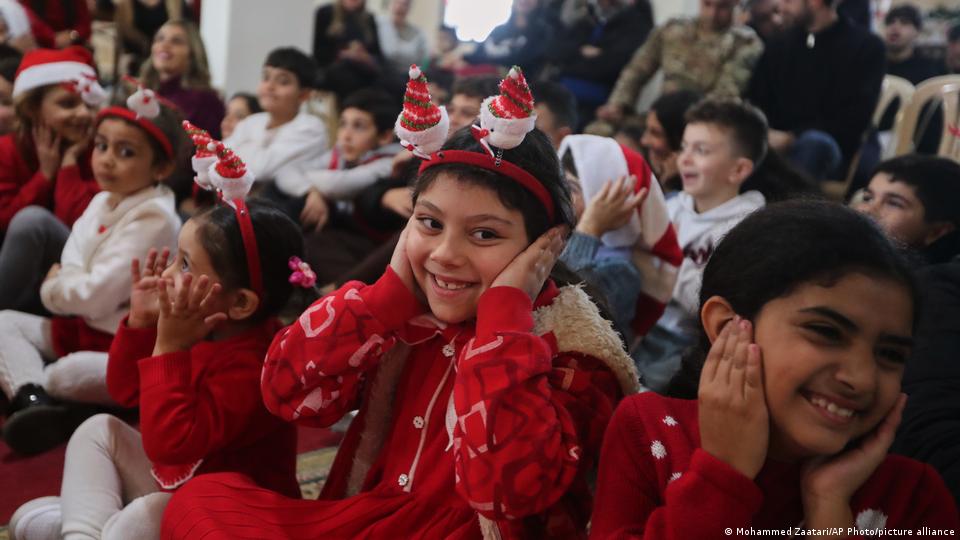 Children cover their ears as they smile on Dec 24, 2025