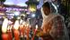A worshiper lights a candle in amongst a number of lit candles on Dec 24, 2025