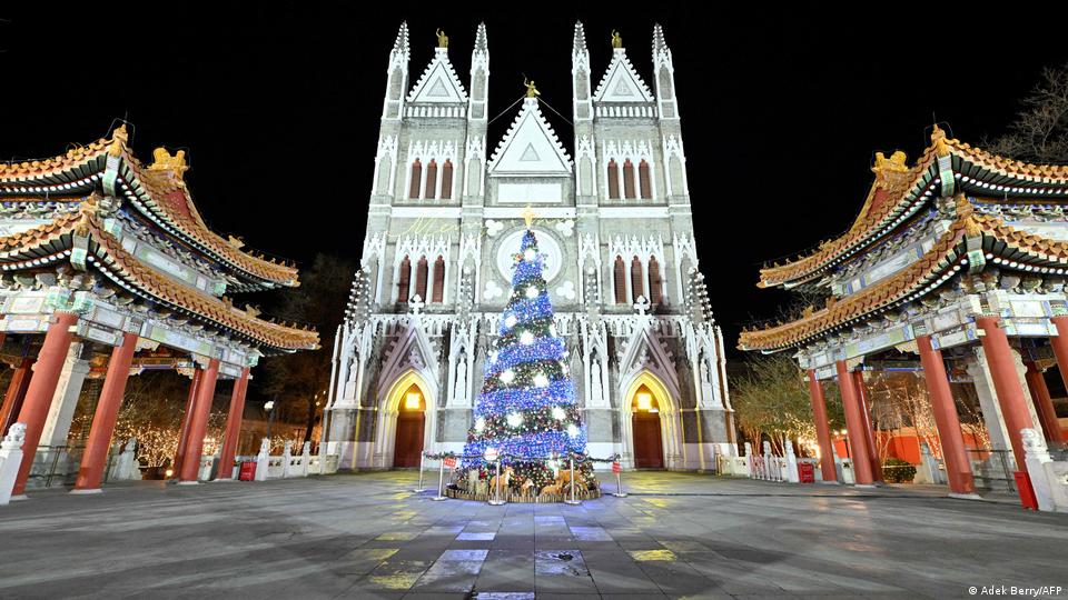 A Christmas tree, lit in blue, stands in front of the Xishiku Church 