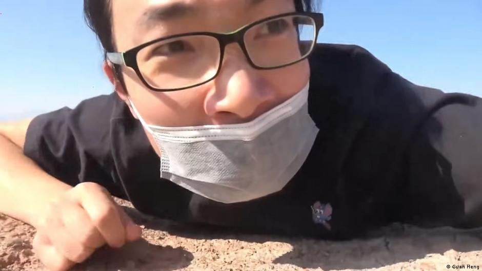 关恒2020年在新疆拍下据信为新疆再教育营设施的珍贵影像纪录，图为他趴在地上，试图用自拍镜头偷拍有关设施。