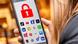 mujer joven con teléfono celular en su mano, en el que se ven los íconos de las redes sociales y el símbolo de un candado en color rojo. mujer joven con teléfono celular en su mano, en el que se ven los íconos de las redes sociales y el símbolo de un candado en color rojo.