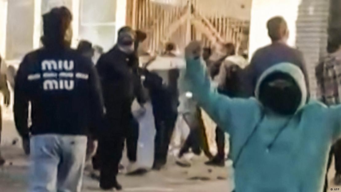 Teils vermummte Protestierende im Iran vor dem Tor eines Gebäudes (31.12.2025) Teils vermummte Protestierende im Iran vor dem Tor eines Gebäudes (31.12.2025)