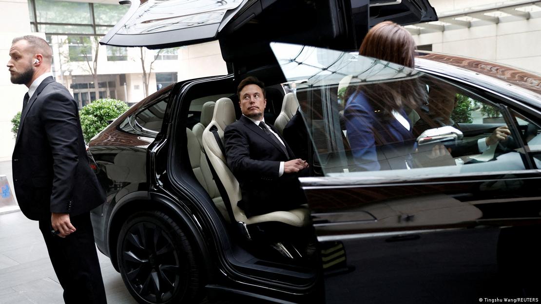 Elon Musk desembarca de carro de luxo com assessores e seguranças ao seu redor na China
