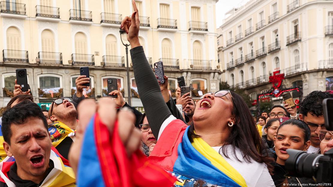Spanien Madrid 2026 | Jubel über Festnahme von Nicolás Maduro nach US-Angriff. Eine Frau reckt den rechten Arm nach oben inmitten einer Menschenmenge Spanien Madrid 2026 | Jubel über Festnahme von Nicolás Maduro nach US-Angriff. Eine Frau reckt den rechten Arm nach oben inmitten einer Menschenmenge