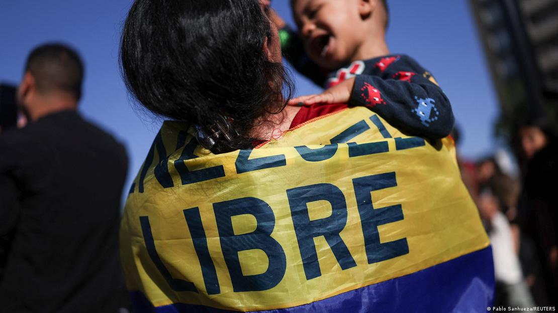Mulher envolta em bandeira com os dizeres "Libre" ("livre") abraça filho em Santiago, no Chile
