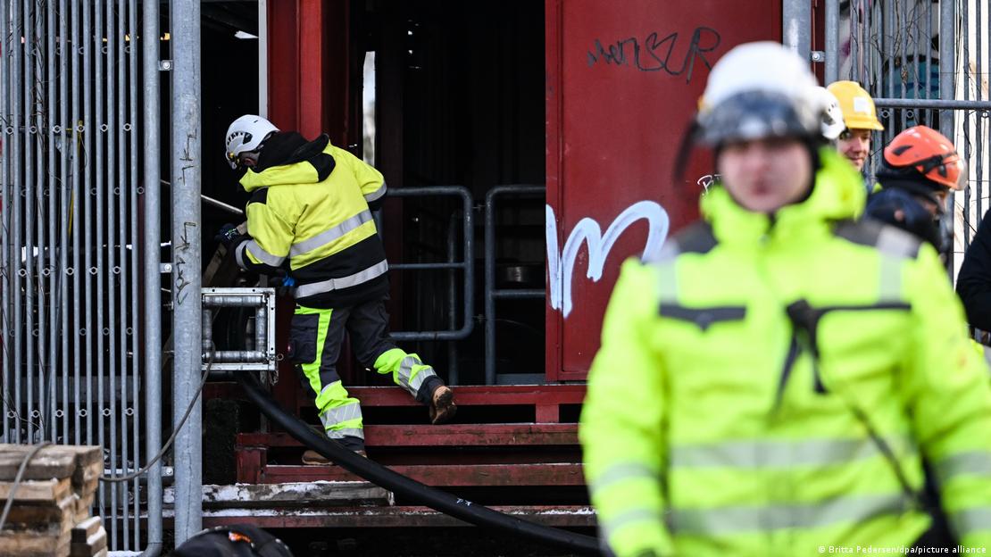 Sarı ceketli görevliler yanan kabloları onarmak üzere çalışıyor