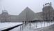 Pirâmide do Museu do Louvre e prédios ao fundo cobertos de neve Pirâmide do Museu do Louvre e prédios ao fundo cobertos de neve