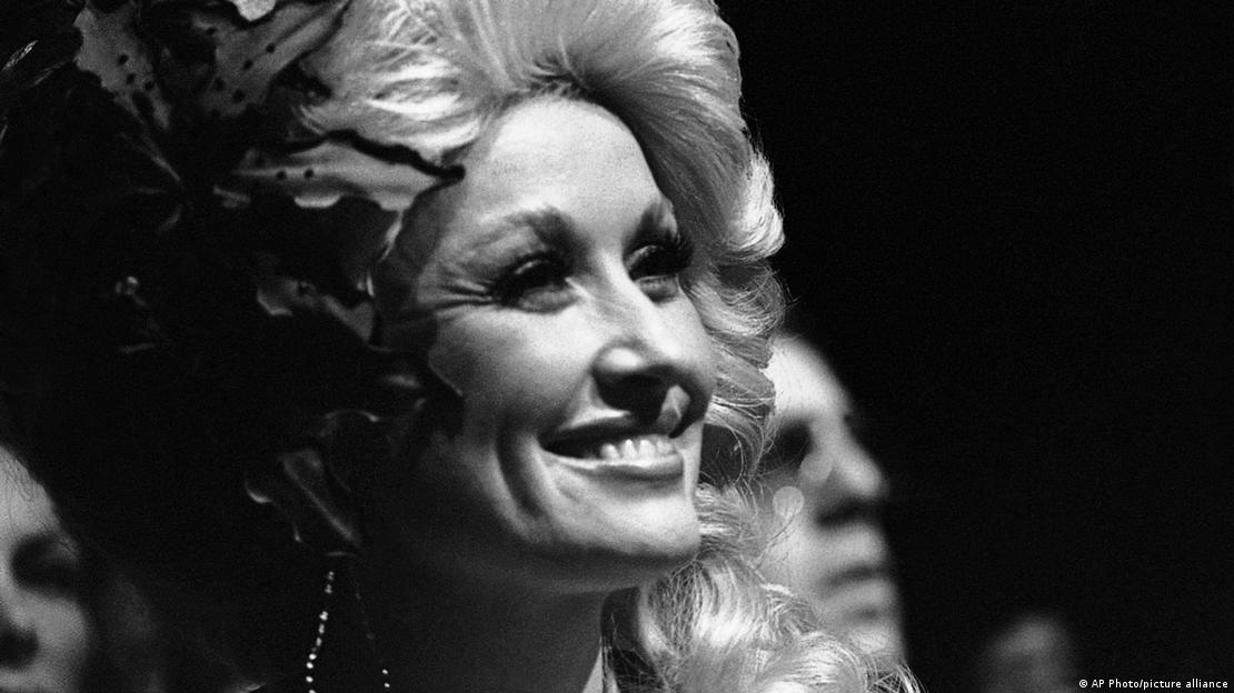Black-and-white photo of Dolly Parton smiling in 1977.