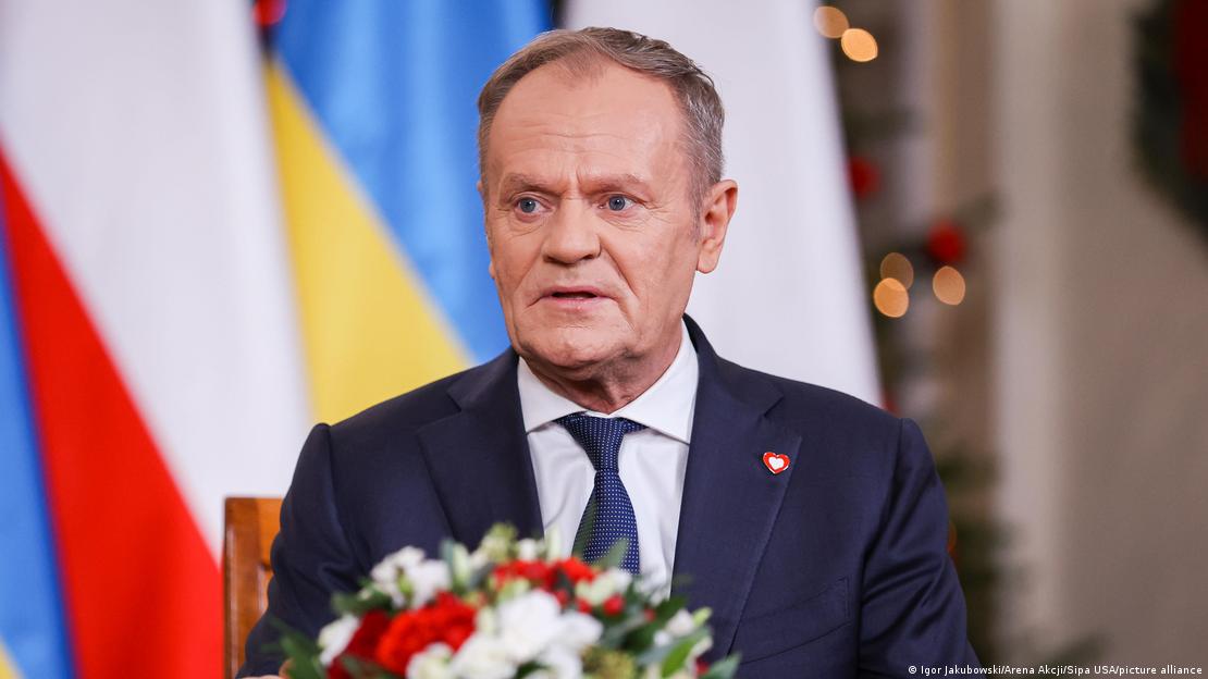 Donald Tusk, primer ministro de Polonia. Atrás, banderas. Adelante, arreglo floral. Donald Tusk, primer ministro de Polonia. Atrás, banderas. Adelante, arreglo floral.