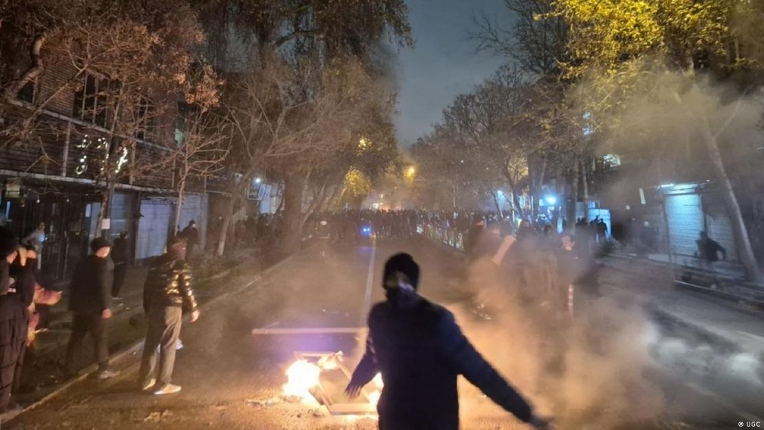 ایران، احتجاج میں شریک ایک شخص سڑک پر اشیا کو آگ لگاتے ہوئے۔ 