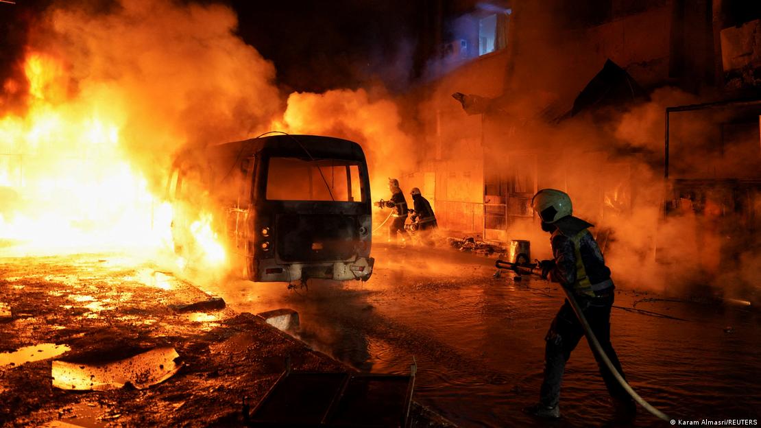 Members of the Syrian Civil Defence work to extinguish a fire after shelling amid renewed clashes between the Syrian army and the Syrian Democratic Forces in Aleppo, Syria