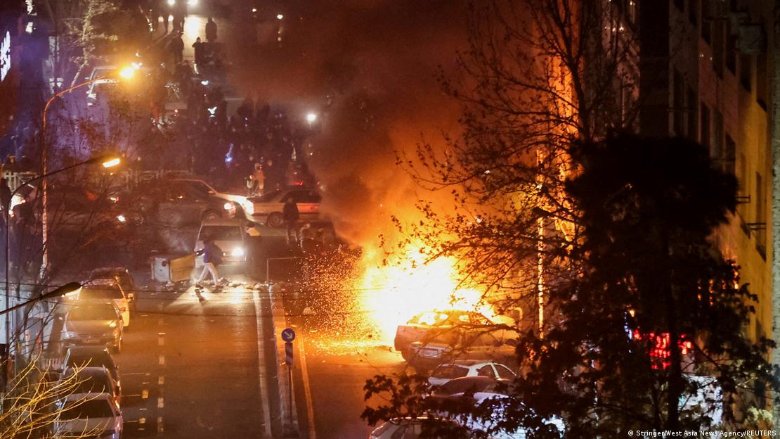 Tahran sokaklarındaki protesto gösterileri sırasında yanan bir araç.