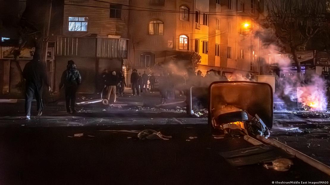 Manifestantes bloqueiam uma rua com fogo e destroços Manifestantes bloqueiam uma rua com fogo e destroços