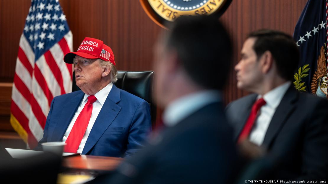 USA Washington D.C. 2025 | Donald Trump sitzt mit einer roten Mütze mit der Aufschrift "Make America Great Again" neben Außenminister Marco Rubio vor einer US-Flagge an einem Tisch USA Washington D.C. 2025 | Donald Trump sitzt mit einer roten Mütze mit der Aufschrift "Make America Great Again" neben Außenminister Marco Rubio vor einer US-Flagge an einem Tisch