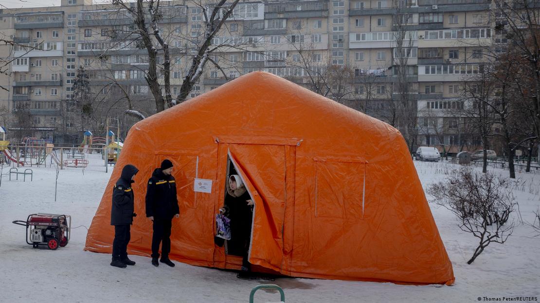 Una mujer sale de una carpa proporcionada por los servicios de emergencia para que los residentes se calienten en un barrio donde los apartamentos se quedaron sin calefacción en Kiev.