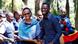 Bobi Wine with his wife Barbara, man and woman smiling in front of group of other people Bobi Wine with his wife Barbara, man and woman smiling in front of group of other people
