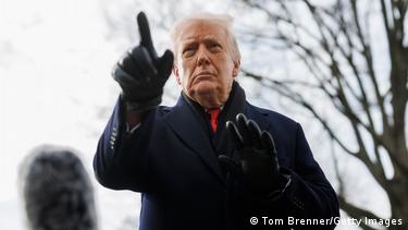 Маж со темно палто и ракавици на рацете и кренат прст - американскиот претседател Доналд Трамп Маж со темно палто и ракавици на рацете и кренат прст - американскиот претседател Доналд Трамп