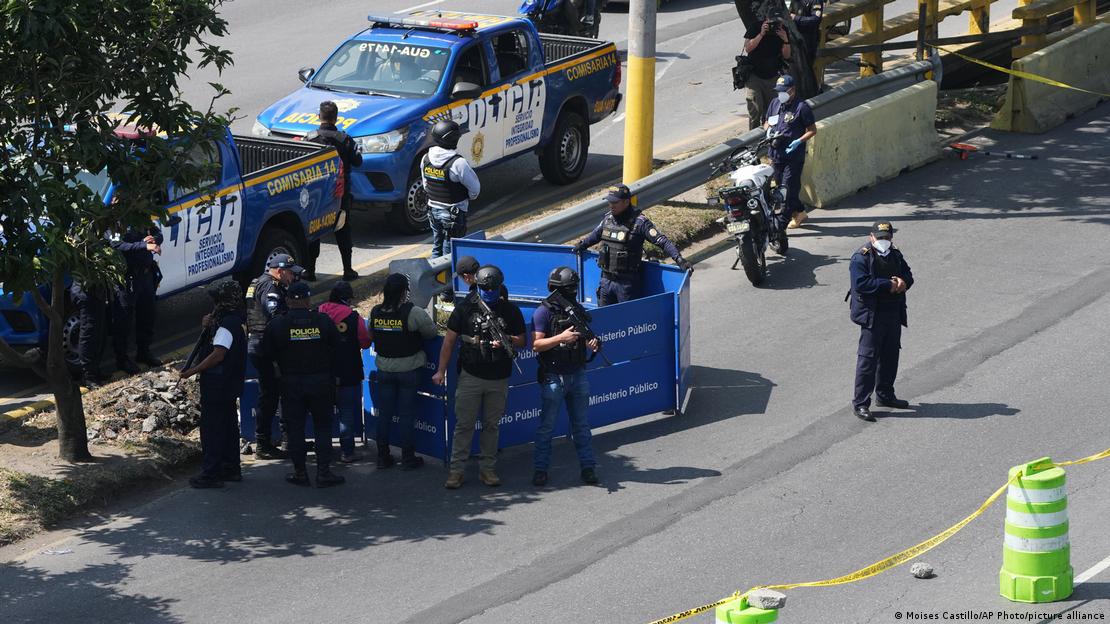 La policía custodia la zona mientras los investigadores forenses examinan el cuerpo de uno de los agentes asesinados. Los ataques se registraron después de que las fuerzas de seguridad retomaran el control de una prisión que alberga a líderes de pandillas en Ciudad de Guatemala.