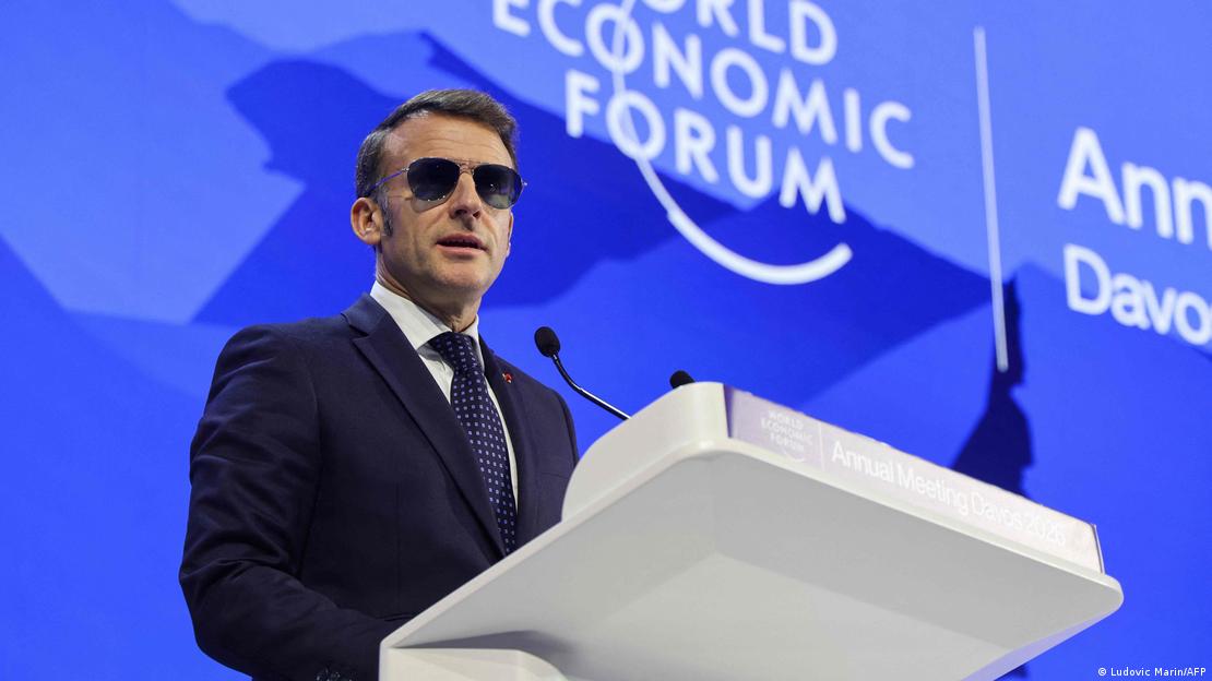 Emmanuel Macron, Davos Zirvesi sırasında kürsüde konuşuyor. Macron kapalı mekanda güneş gözlüğü takıyor