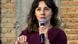Portrait of Tatiana Dias holding a microphone