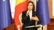 Femeie în taior negru și cămașă albă vorbește la un microfon: Maia Sandu. În spatele ei, steagurile R. Moldova și UE Femeie în taior negru și cămașă albă vorbește la un microfon: Maia Sandu. În spatele ei, steagurile R. Moldova și UE