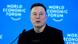 Elon Musk with a microphone in front of a blue background announcing the World Economic Forum  meeting in Davos, Switzerland