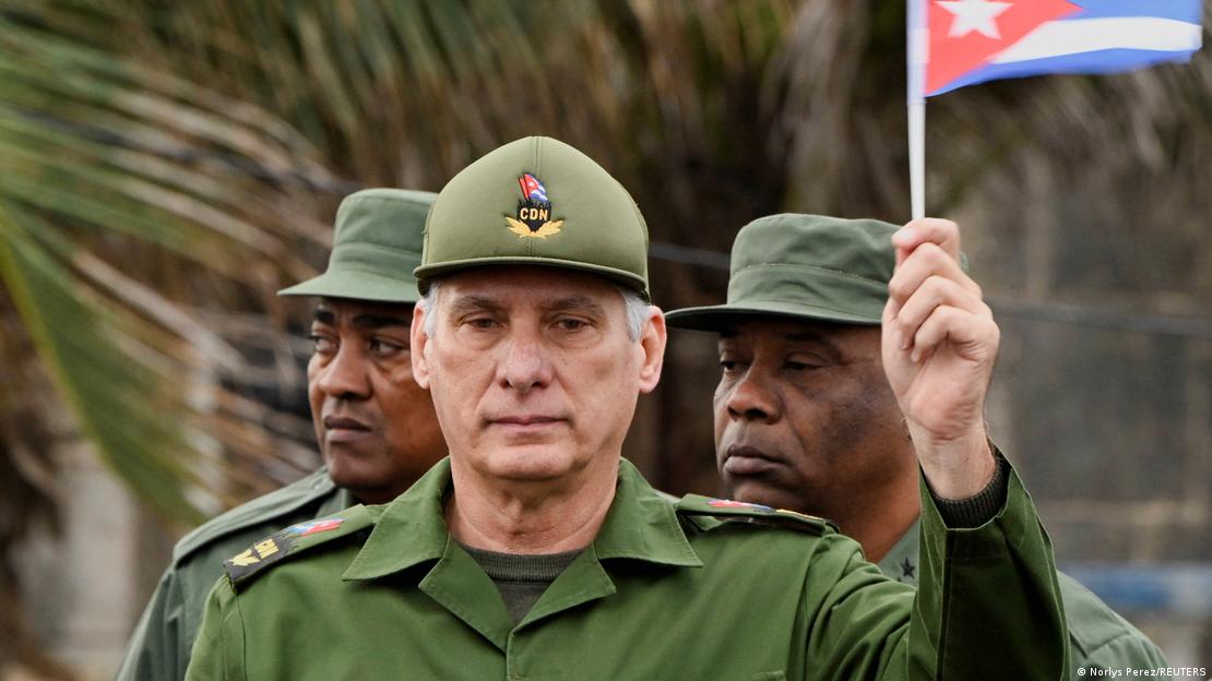 El presidente de Cuba, Miguel Díaz-Canel, sostiene una bandera cubana en la mano.