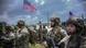 Uniformierte und bewaffnete Soldaten, Militärfahrzeuge und zwei US-Flaggen: Multinationale NATO-Militärübung auf dem bulgarischen Truppenübungsplatz Novo Selo Uniformierte und bewaffnete Soldaten, Militärfahrzeuge und zwei US-Flaggen: Multinationale NATO-Militärübung auf dem bulgarischen Truppenübungsplatz Novo Selo