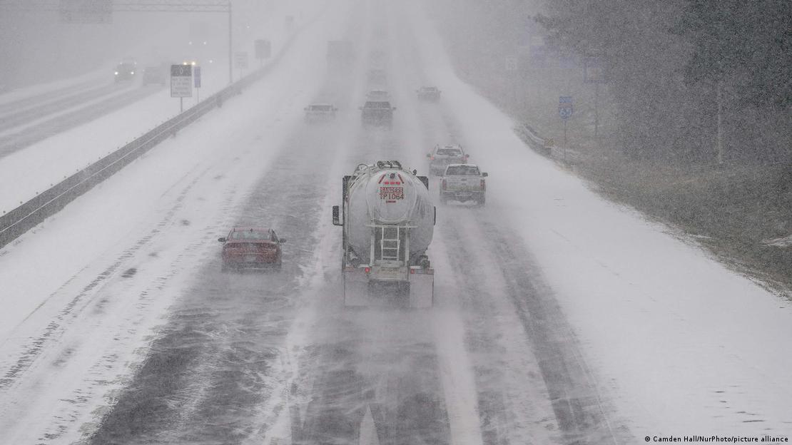 Veículos atravessam estrada coberta de gelo e neve nos EUA Veículos atravessam estrada coberta de gelo e neve nos EUA