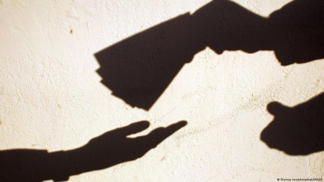 Fotgrafi bardh e zi simbol që tregon nje dorë me para duke ia kaluar ato një doe tjetër.