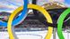 Le logo des JO devant une montagne et le stand de tir de biathlon Le logo des JO devant une montagne et le stand de tir de biathlon