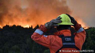 En Cholila, Chubut, Patagonia argentina, un bombero mira hacia las llamas y el humo de graves incendios forestales, el 1.02.2026.