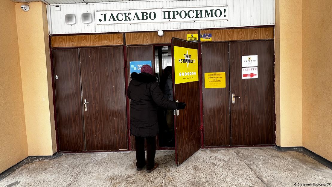 Una mujer entra a uno de los llamados "puntos de invencibilidad" de Kiev. En el letrero se lee: "¡Bienvenidos!"