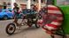 A man pushes a tricycle loaded with crates past a sports vehicle displaying a wheel covered with a stylized image of the US flag and a bald eagle, parked in the streets of Havana, Cuba A man pushes a tricycle loaded with crates past a sports vehicle displaying a wheel covered with a stylized image of the US flag and a bald eagle, parked in the streets of Havana, Cuba